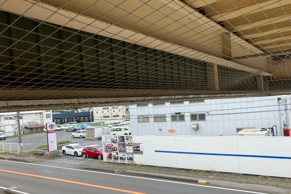 工場の波板外壁と軒下天井の境界に隙間なく固定された防鳥ネット。鳥が入り込みやすい複雑な隙間を完全に塞ぎ、営巣やフン害を徹底的に防ぐ施工事例