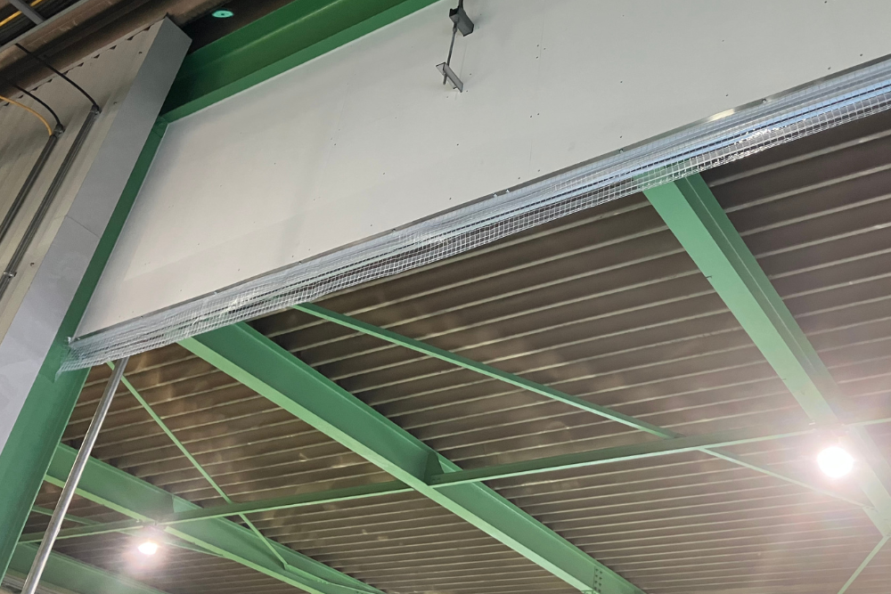 糸入り透明ビニールカーテンの垂れネットを設置している画像。垂れネットを設置することで、カーテンの隙間からの空調対策に効果的