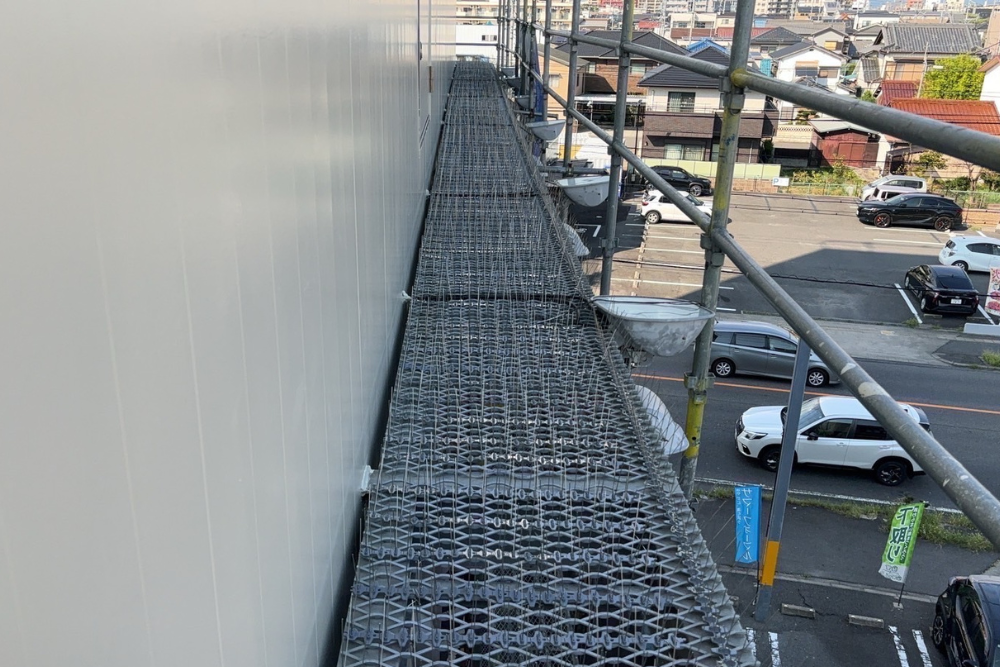 ビルのメンテナンス通路に設置された鳥害対策用の防鳥ピン。等間隔に並んだステンレス製のピンが、鳩やカラスの飛来と停滞を防ぎ、建物や足場の清潔を維持します。