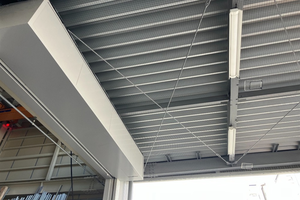 工場や倉庫の鉄骨天井全体に、照明器具を避けながら広範囲にわたって鳥よけネットを綺麗に張り巡らせた施工事例