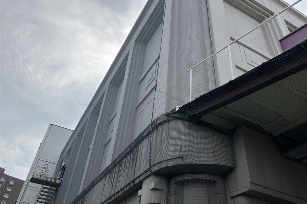建物外壁に外壁剥落防護ネットを施工した事例。タイルやコンクリート片の落下事故を防ぐ安全対策